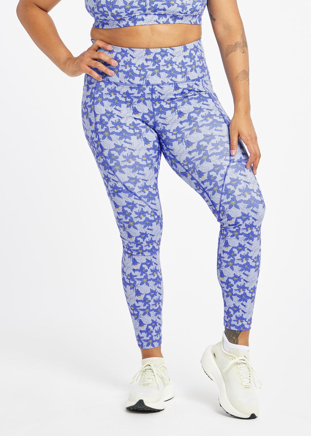 Woman wearing blue with blue flower print  running tights in size 12, front view